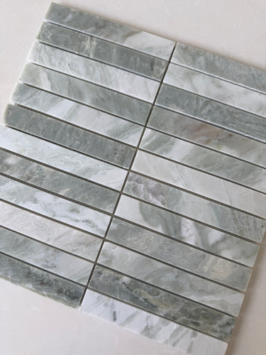 White Mix 11x11 natural stone pebble mosaic tile wall tile from Roca, showing a close-up of textured, multicolored stone pebbles.