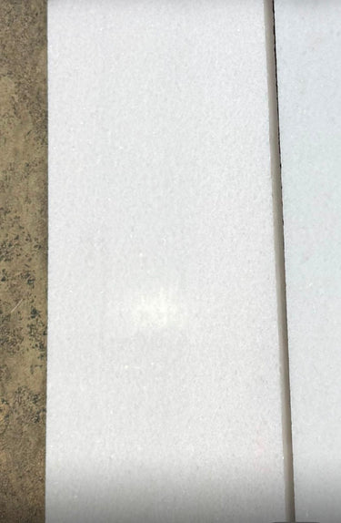 Polar white 12x24 polished natural stone tile from RN, showcasing smooth, glossy surface and modern rectangular shape.