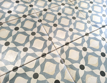 European-inspired decorative porcelain tile floor featuring intricate blue and white motifs