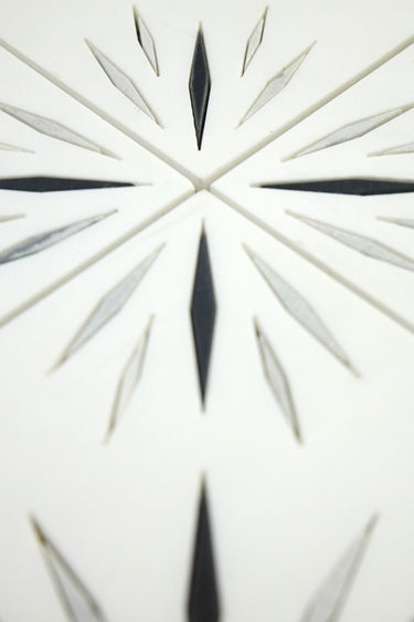 Close-up of Harmony White Waterjet Marble Mosaic Tile by Mythology Tile, showcasing intricate white and black marble pattern details.