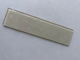 Roca LUX Champagne 3x12 natural stone glass tile for wall installation, showcasing a sleek, reflective surface in a champagne hue.