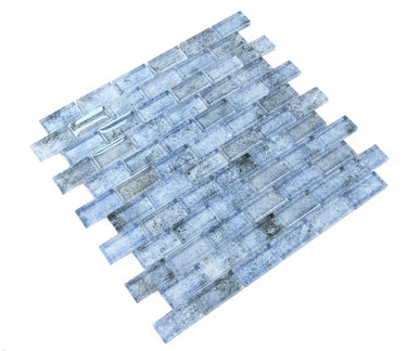 Pool-rated Crystal Aqua Sofia 1x2 glass mosaic tile installed on a luxury swimming pool waterline with reflective glass surfaces.