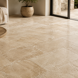 Premium natural stone tile floor installation in a modern living room featuring large-format beige tiles with a seamless indoor-outdoor design.