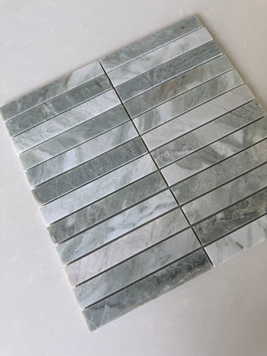 White Mix 11x11 natural stone pebble mosaic tile wall tile by Roca, showing a close-up of textured, multicolored stone pebbles.