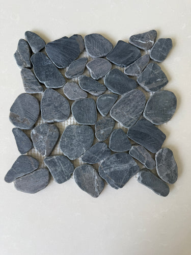 Black 11x11 natural stone pebble mosaic tile for wall installation by Roca, showing textured pebble surface and mosaic pattern.