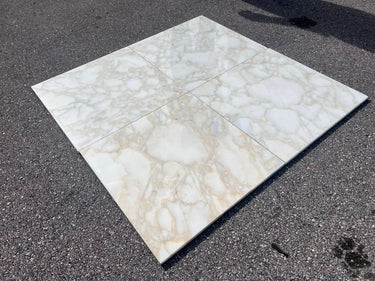 Calacatta Gold Giorgio 18x18 polished natural stone tile with white and gold veining, branded RN, showing a close-up of the surface texture.