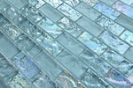 Aqua and turquoise glass mosaic tile used as a kitchen backsplash featuring a classic 1x2 brick pattern and tropical-inspired tones.