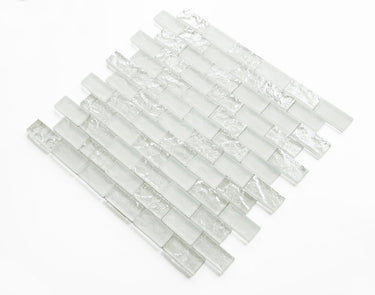 Crystal Aqua Soho White 1x2 glass mosaic tile installed on a bathroom shower wall with clean white tones and reflective glass surfaces.