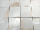 Mediterranean-inspired glazed porcelain backsplash in soft ivory tones
