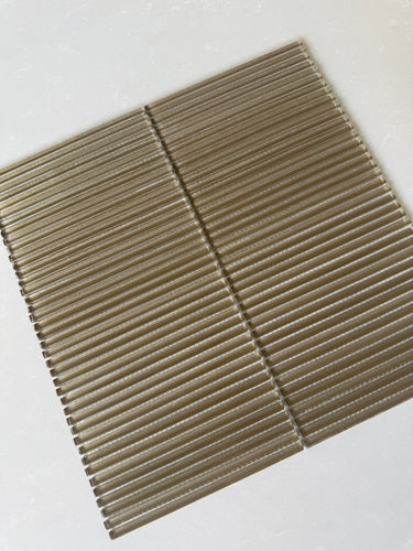 Lux Bronze 12x12 flutted glass mosaic wall tile by Roca, showcasing textured bronze tiles for modern interior design.