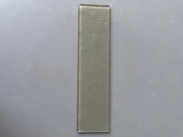 Natural stone backsplash featuring Roca Lux Champagne 3x12 glass tiles with a glossy finish and elegant color variation.