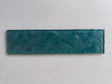 Emerald green glass tile from Roca, 3x12-inch natural stone tile with a glossy finish, detailed close-up.