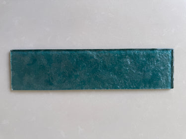 Emerald green glass tile from Roca, 3x12-inch natural stone tile with a glossy finish, detailed close-up.
