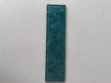 Emerald green glass tile by Roca, 3x12 inch natural stone tile for wall installation, showcasing a glossy, vibrant green finish.