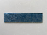 Roca LUX Indigo 3x12 glass tile wall featuring natural stone appearance, vibrant blue and indigo shades, sleek and modern design