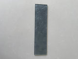 Close-up of Roca LUX Pewter 3x12 glass tile showing its natural stone texture and sleek, modern finish.
