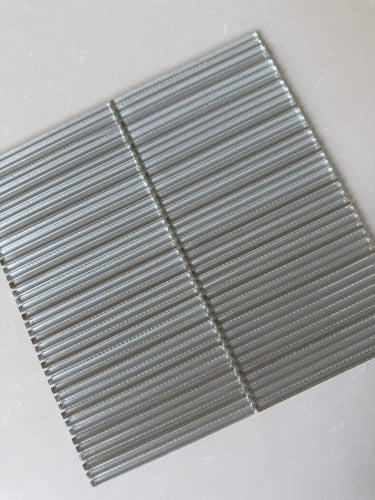 Roca Lux Sand 12x12 fluted glass mosaic wall tile, showcasing a textured, sandy-toned backsplash with a modern design.