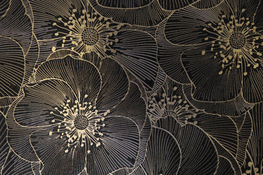 Close-up of Mythology Tile Golden Blossom Nero 18x18 floral mosaic tile with detailed black floral pattern and textured surface.