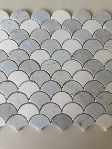 Natural stone tile featuring a blue mix, Carrara and Thassos marble, arranged in a fan pattern for backsplash or wall use by Roca.