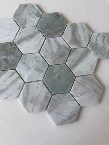 Green marble hexagon mosaic tile by Roca featuring natural stone texture and intricate pattern, perfect for elegant shower designs.