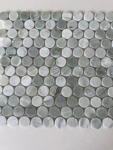 Green Mix penny round natural stone mosaic installed on a sophisticated shower wall
