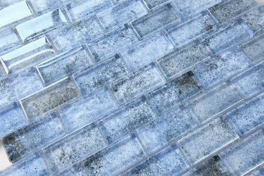 Crystal Aqua Sofia 1x2 glass mosaic tile used as a kitchen backsplash featuring a classic brick mosaic pattern and reflective glass finish.