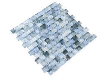 Pool-rated Stromboli Sky Blue glass mosaic tile installed on a luxury swimming pool waterline with bright blue reflective tones.