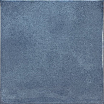 Roca Olaria blue steel 2x6 bullnose wall tile showing a close-up of the textured blue ceramic surface